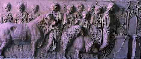 A bull, sheep and pig are led to the altar by a cowled figure and attendants with axe