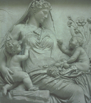 Detail from the relief panel on the east side of the Ara Pacis showing Roma or Venus or Italia personified as a female figure with two children in her arms and surrounded by symbols of fertility, abundance and happiness: an allegory of the peace, secured by Augustus, which the Altar celebrates.